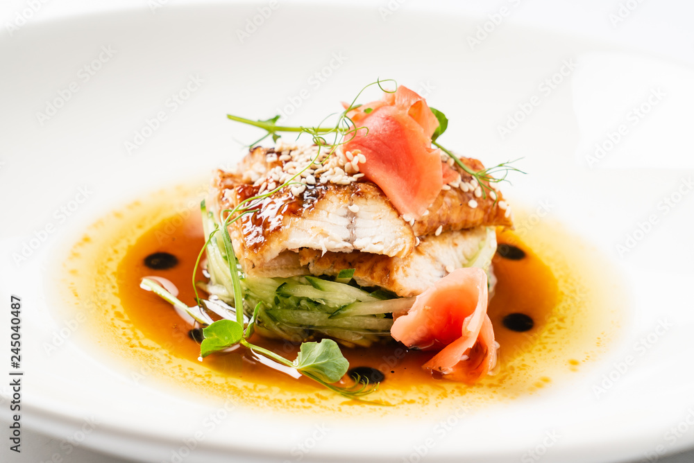 Fried eel with vegetables on the white plate