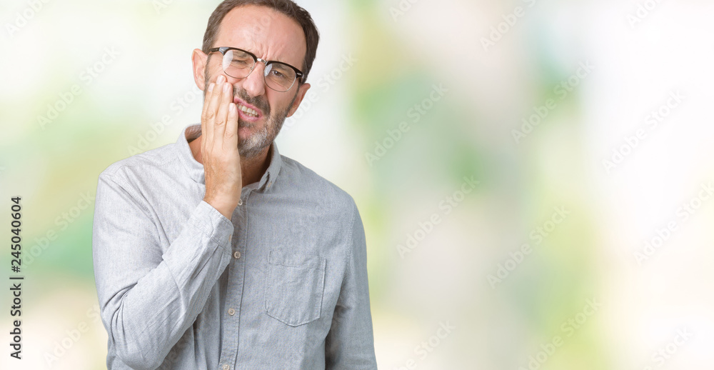 Handsome middle age elegant senior man wearing glasses over isolated background touching mouth with hand with painful expression because of toothache or dental illness on teeth. Dentist concept. Handsome middle age elegant senior man wearing glasses over isolated background touching mouth with hand with painful expression because of toothache or dental illness on teeth. Dentist concept.