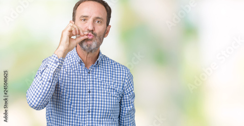 Fototapeta Naklejka Na Ścianę i Meble -  Handsome middle age elegant senior man over isolated background mouth and lips shut as zip with fingers. Secret and silent, taboo talking