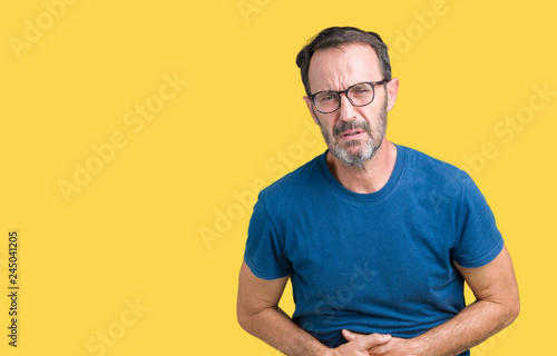 Handsome middle age hoary senior man wearin glasses over isolated background with hand on stomach because indigestion, painful illness feeling unwell. Ache concept.