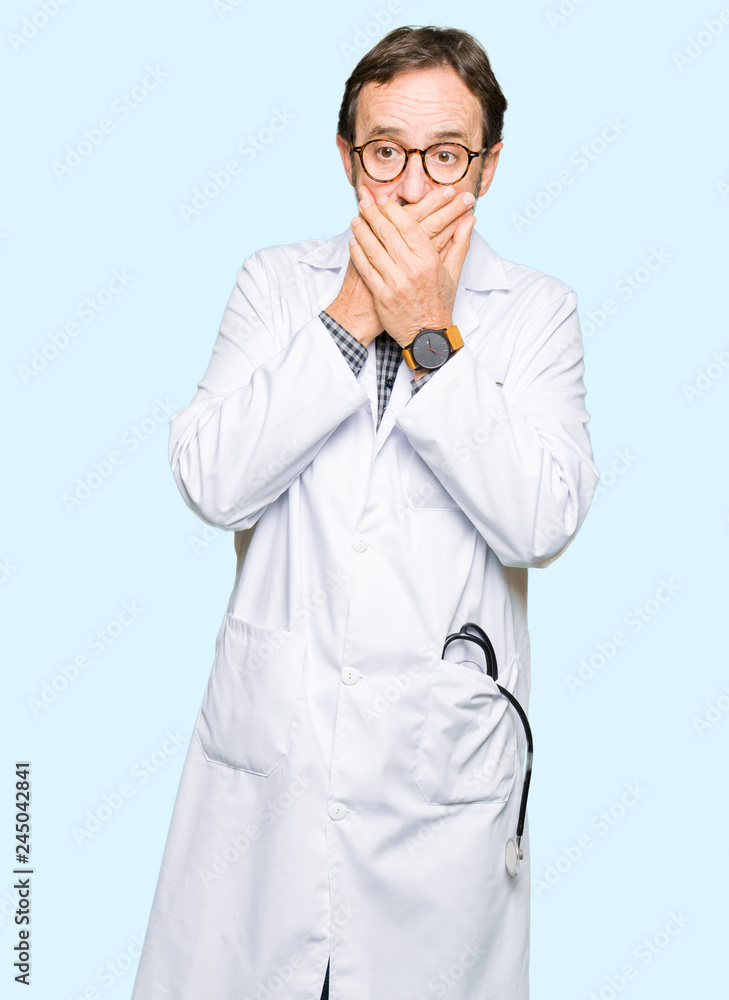 Middle age doctor men wearing medical coat shocked covering mouth with hands for mistake. Secret concept. Middle age doctor men wearing medical coat shocked covering mouth with hands for mistake. Secret concept.