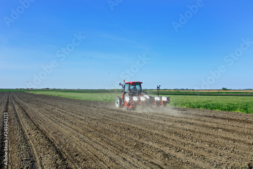 Farmer with a tractor sows corn