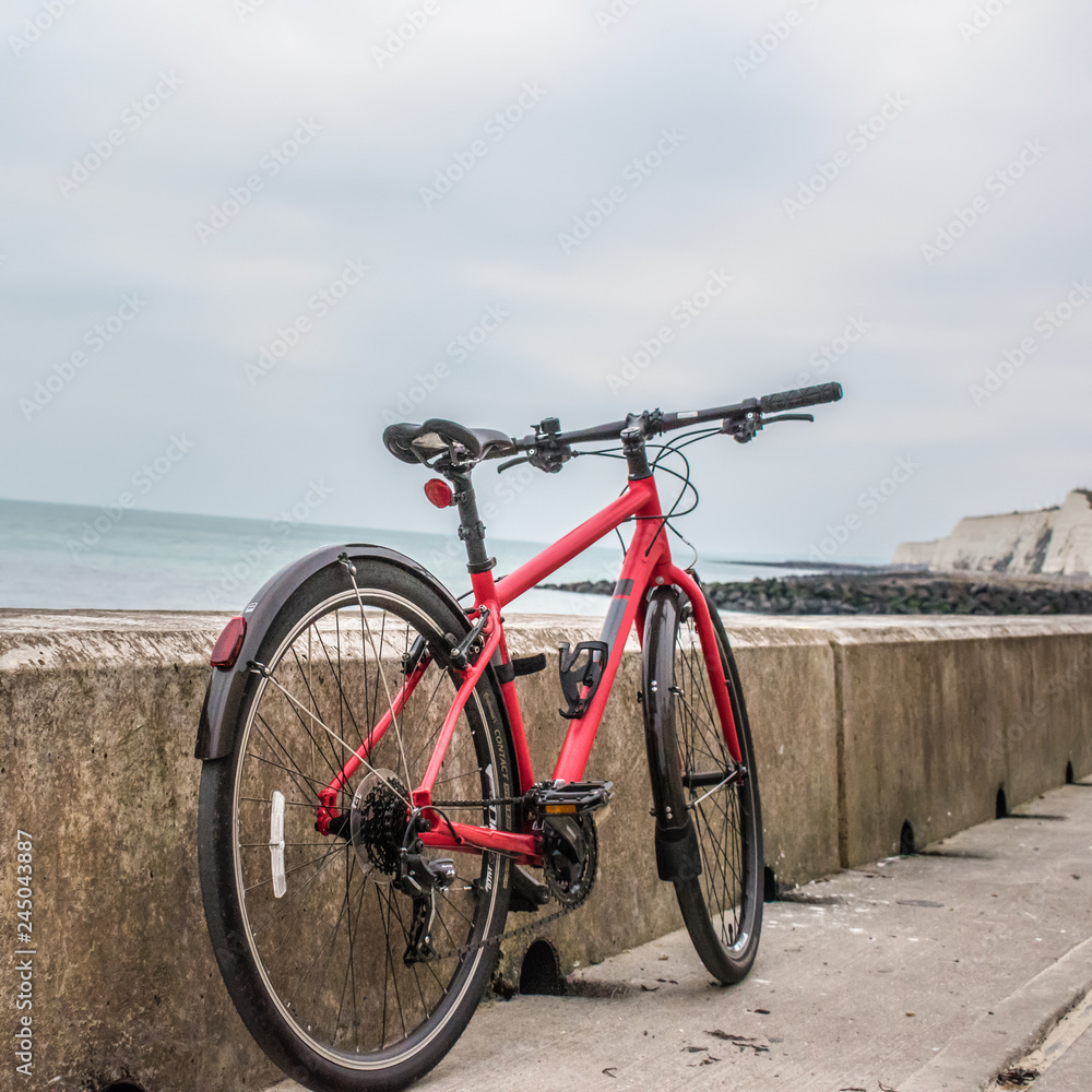 Bicycle by the beach with an ocean backdrop and cliffs