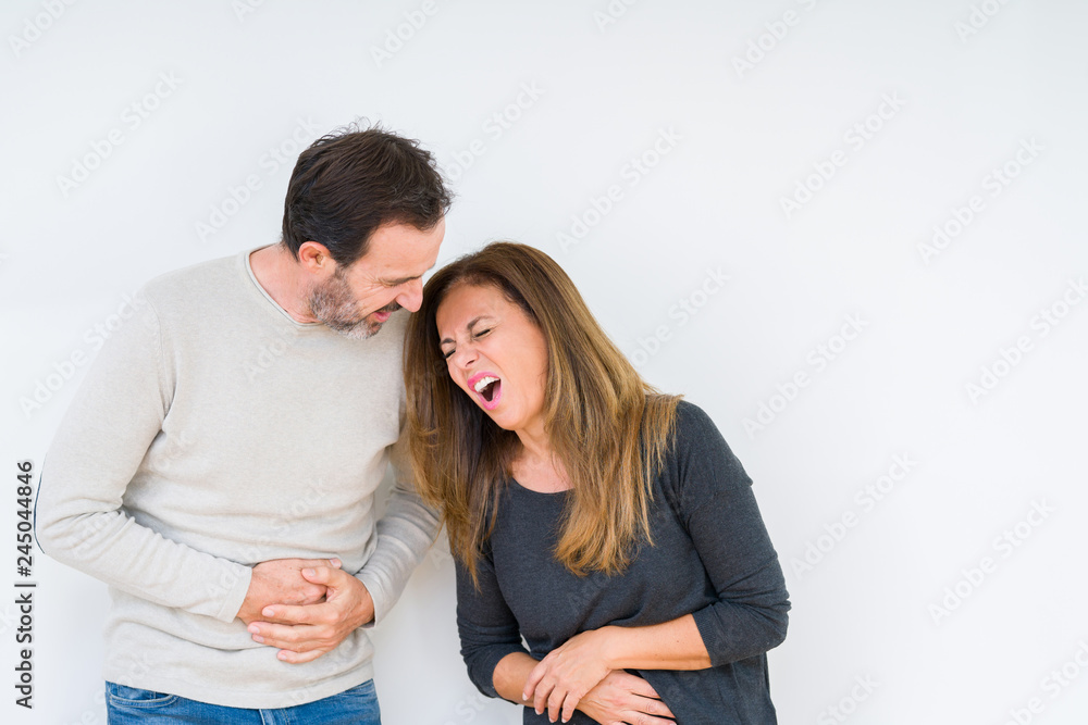 Beautiful middle age couple in love over isolated background with hand on stomach because nausea, painful disease feeling unwell. Ache concept. Beautiful middle age couple in love over isolated background with hand on stomach because nausea, painful disease feeling unwell. Ache concept.