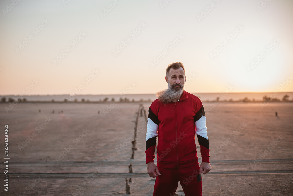 Portrait of handsome bearded mature man in sports suit, outdoors during sunset or sunrise Portrait of handsome bearded mature man in sports suit, outdoors during sunset or sunrise