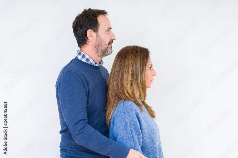 Beautiful middle age couple in love over isolated background looking to side, relax profile pose with natural face with confident smile. Beautiful middle age couple in love over isolated background looking to side, relax profile pose with natural face with confident smile.