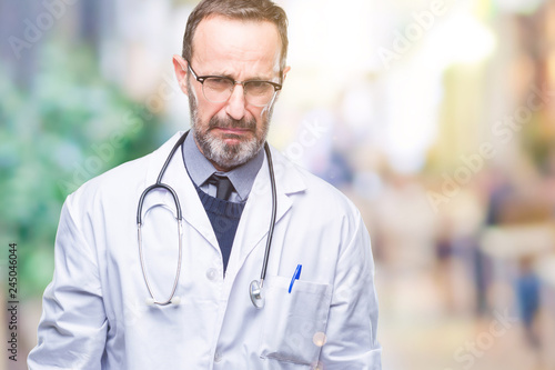 Middle age senior hoary doctor man wearing medical uniform isolated background depressed and worry for distress, crying angry and afraid. Sad expression.