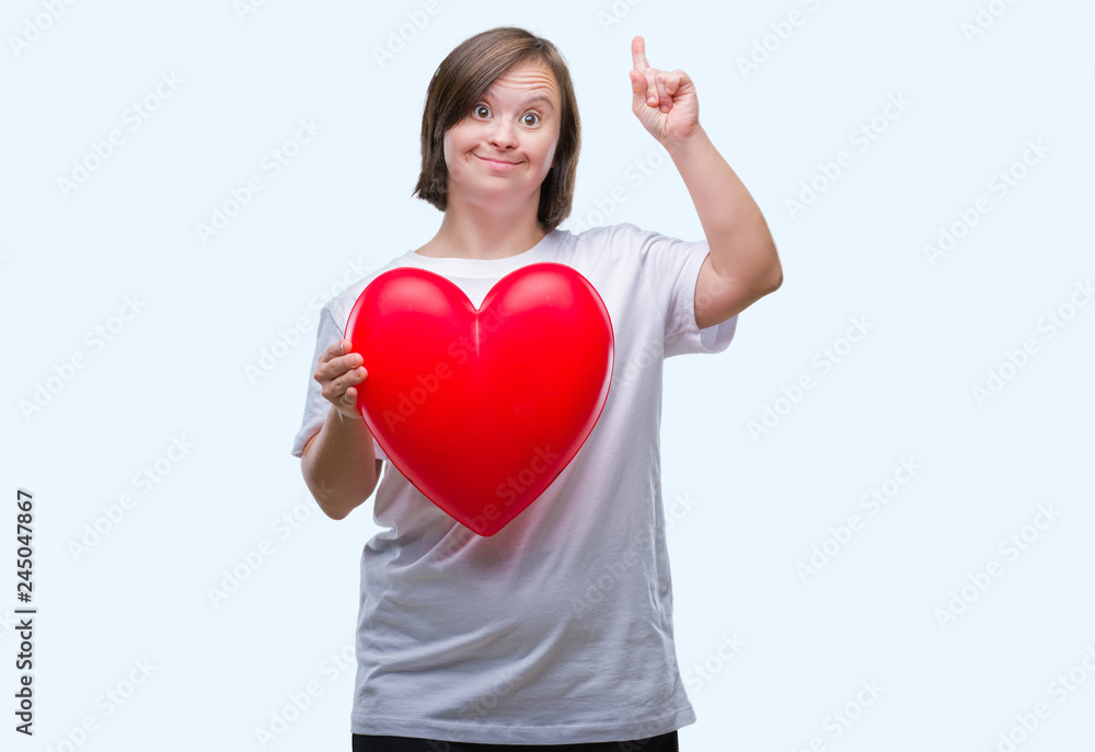 Young adult woman with down syndrome holding red heart over isolated background surprised with an idea or question pointing finger with happy face, number one Young adult woman with down syndrome holding red heart over isolated background surprised with an idea or question pointing finger with happy face, number one