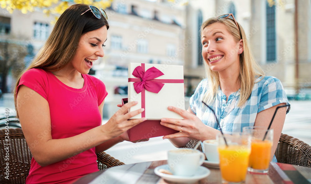 Two beautiful girls drinking coffee in the cafe after shopping. Consumerism, shopping, lifestyle concept Two beautiful girls drinking coffee in the cafe after shopping. Consumerism, shopping, lifestyle concept