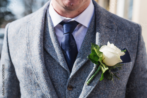 groom displaying his suit and corsage