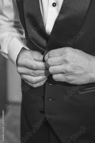 groom fastening his buttons on his suit