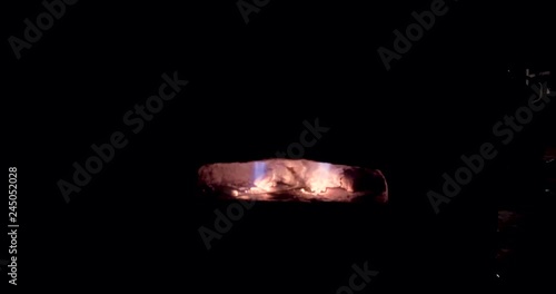 A close up view inside of a forge from the side as it blazes in the dark on a winters night. photo