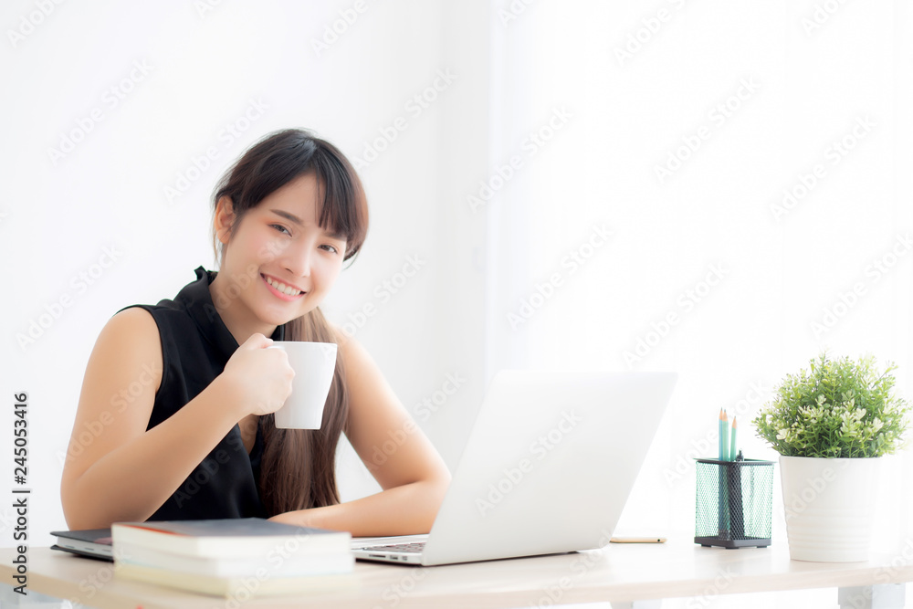 Beautiful young freelance asian woman smiling working and on laptop computer at desk office with professional, girl using notebook and drink coffee, business and lifestyle concept. Beautiful young freelance asian woman smiling working and on laptop computer at desk office with professional, girl using notebook and drink coffee, business and lifestyle concept.
