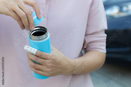Woman hand injury open stainless steel water cylinder, concept of plastic free.