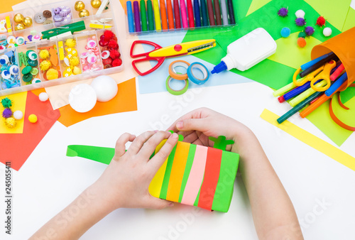 Child makes a hack box chameleon. Material for creativity on a white background.