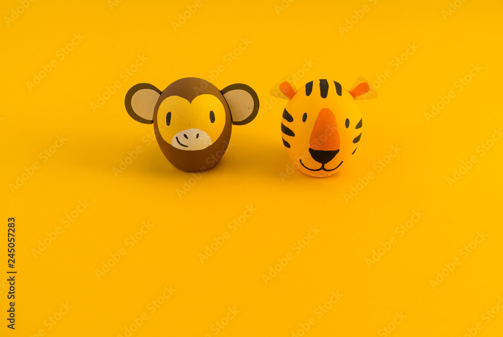Easter holiday concept with cute handmade eggs: orange tiger and monkey. Easter holiday concept with cute handmade eggs: orange tiger and monkey.