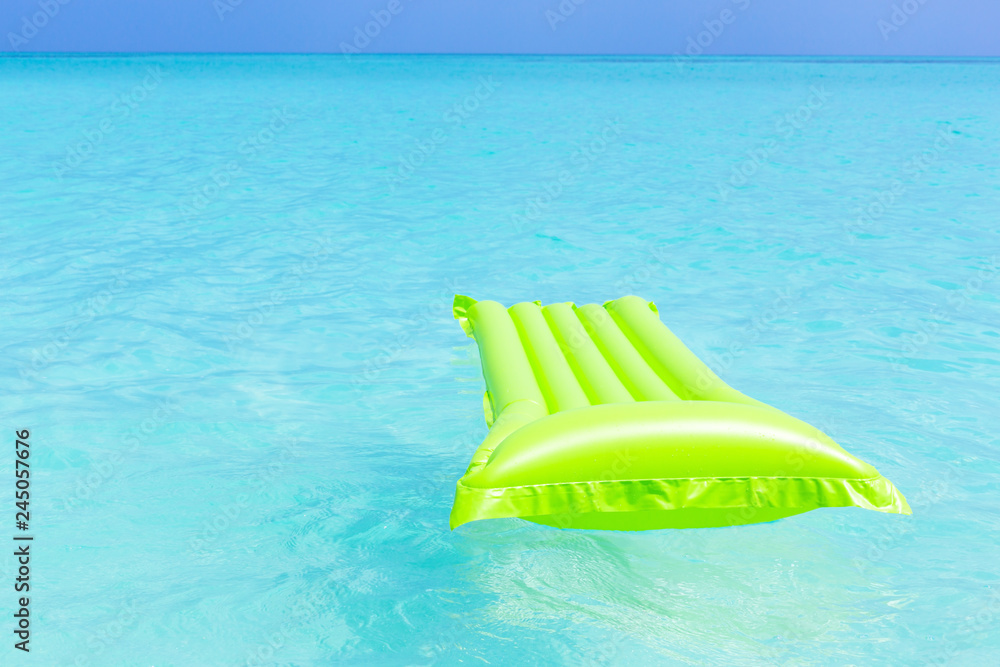 Swimming color green mattress on turquoise sea Swimming color green mattress on turquoise sea