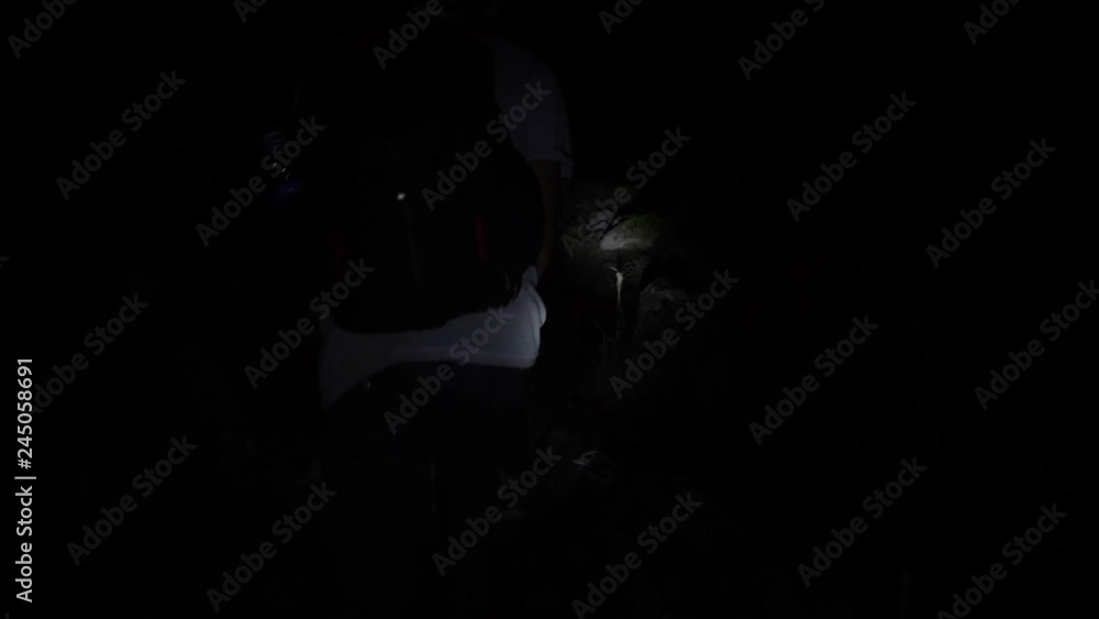 Young Hiker Man Walking with Flashlight on Forest Path at Night. 4K Slowmotion Travel Active Lifestyle Concept. Bali, Indonesia. Young Hiker Man Walking with Flashlight on Forest Path at Night. 4K Slowmotion Travel Active Lifestyle Concept. Bali, Indonesia.