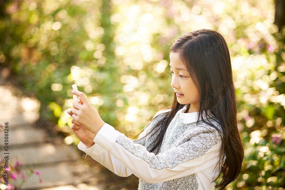 little asian girl taking a selfie using mobile phone little asian girl taking a selfie using mobile phone