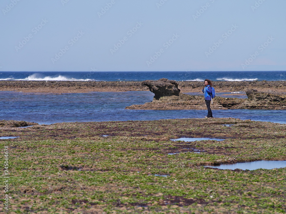 Young woman walking on the rocky coast of Patagonia