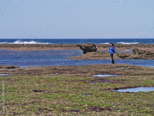 Obraz na płótnie Young woman walking on the rocky coast of Patagonia w salonie