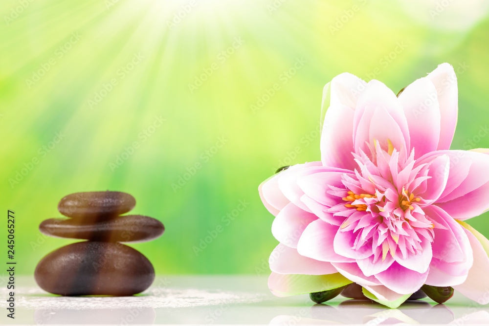 Balanced zen stones with drops of water on a green bokeh background