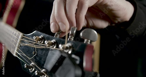 Guitarist hand tuning a guitar