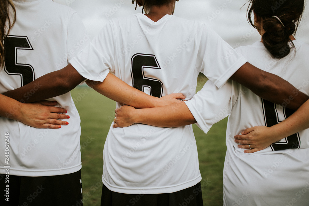 Fototapeta premium Female soccer players huddling and standing together