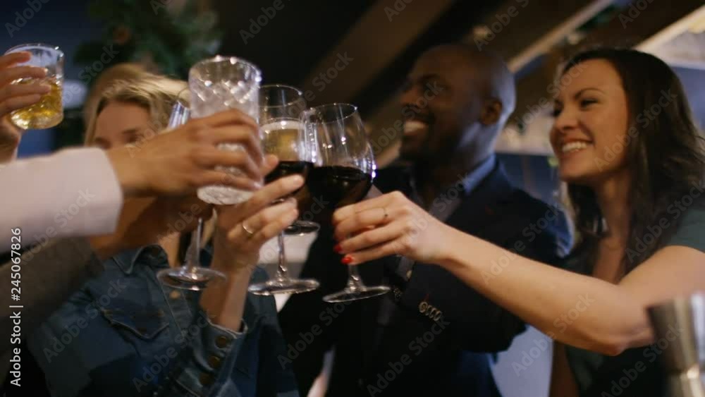 Group of friends at a bar toast to celebrate an occasion Group of friends at a bar toast to celebrate an occasion