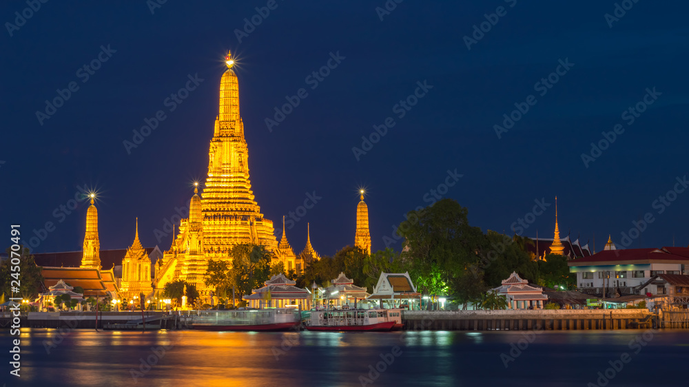 The iconic Temple of Dawn, Wat Arun, along the Chao Phraya river on twilight, Bangkok, Thailand