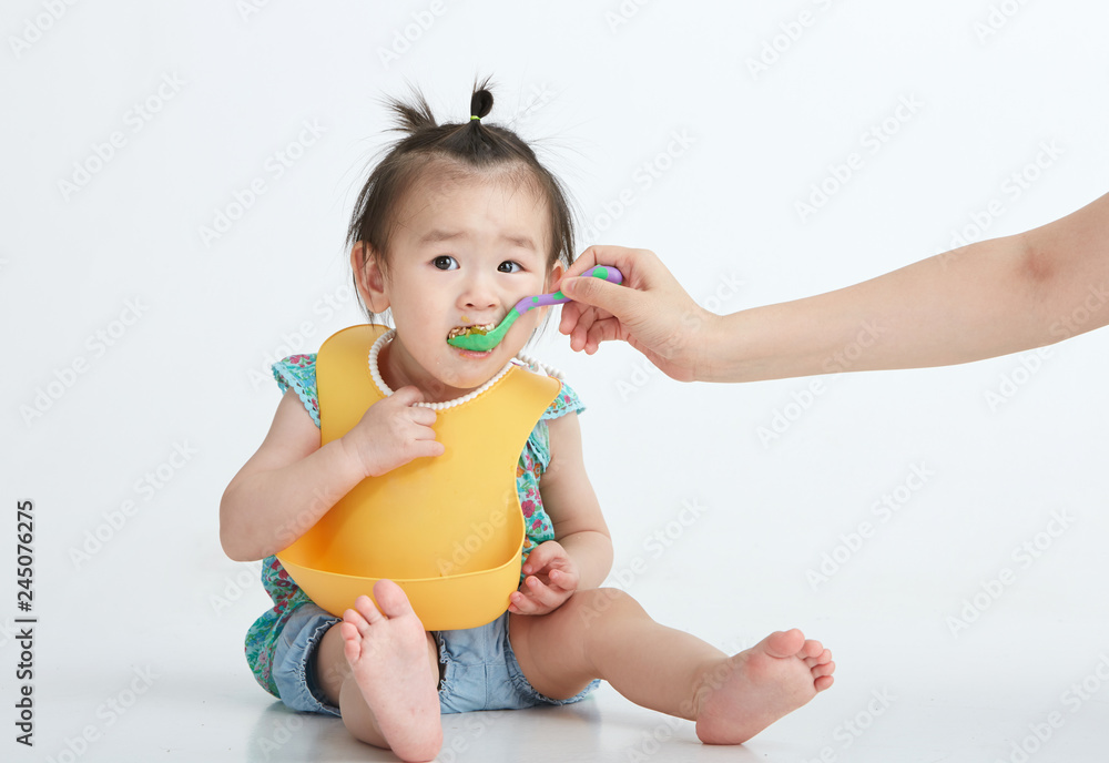 Asian little girl eating, in white background Asian little girl eating, in white background