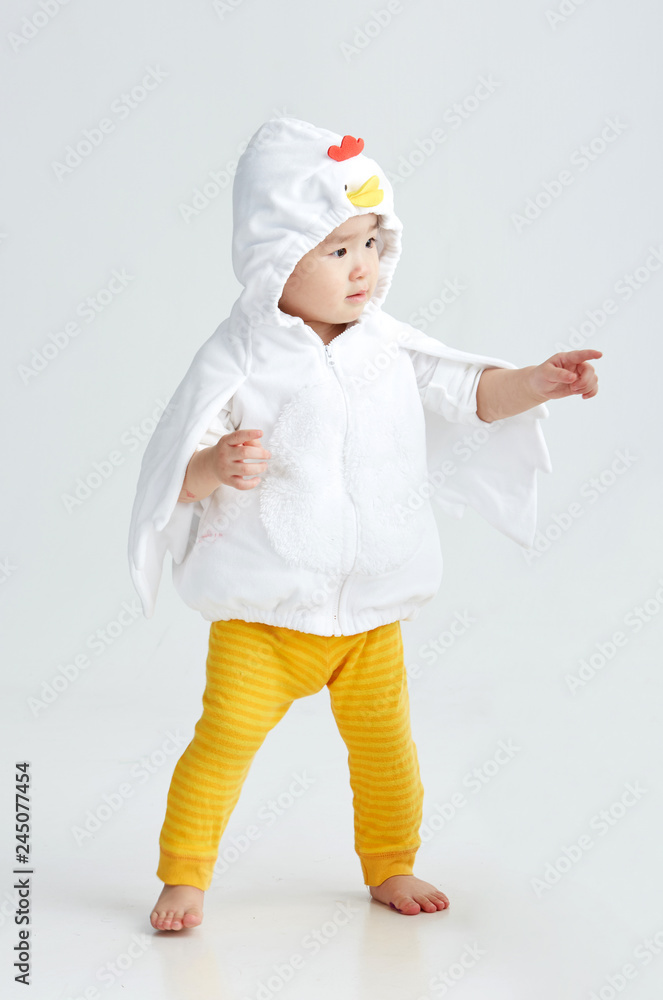 Cute Asian little girl wearing a chicken costume. On white background Cute Asian little girl wearing a chicken costume. On white background