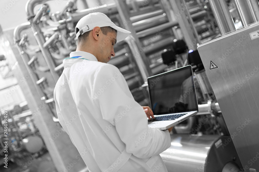 Technologist with a laptop in his hands at the dairy plant Technologist with a laptop in his hands at the dairy plant