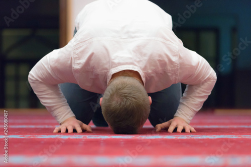 Religious muslim man praying inside the beautiful big mosque.