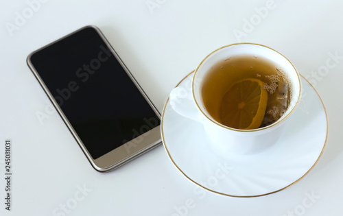 Cup of tea with mobile phone on the table