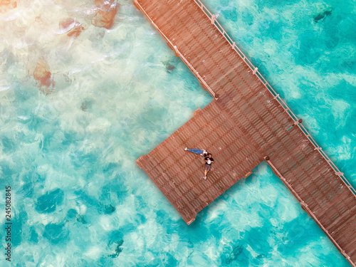 aerial top view of couple lover create symbol body on the wooden pier bridge, roman in vacation holidays and valentine day CONCEPT