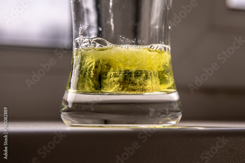 Closeup view at an acidic solution dissolving rust and lime stone from faucet aeration ring.