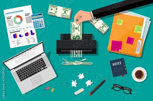 Hand putting dollar banknote in shredder machine