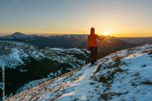 A tourist on the top of the mountain at sunrise with beautiful views.