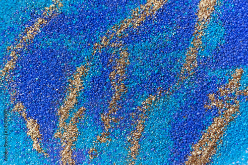 Layered colorful sand pattern. Marble style background. Blue and gold powder texture.