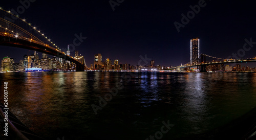 New York at night. Stitched panorama of a lower Manhattan from Empire Fulton Ferry park with Brooklyn and Manhattan bridges. © Dmitry