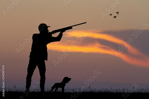 man hunting with the dog at sunset