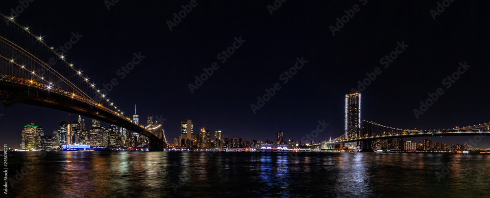 Night wide angle panorama Manhattan panorama with Brooklyn and Manhattan bridges.