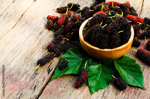 Close up of mulberries fruits in wooden bowl on old wood backgrounds