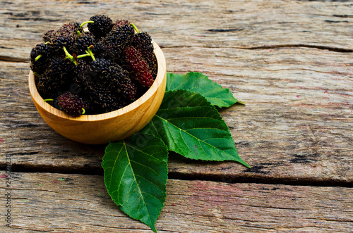 Mulberries organic fruits in wooden bowl on old wood backgrounds