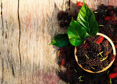 Mulberries organic fruits in wooden bowl on wood backgrounds above