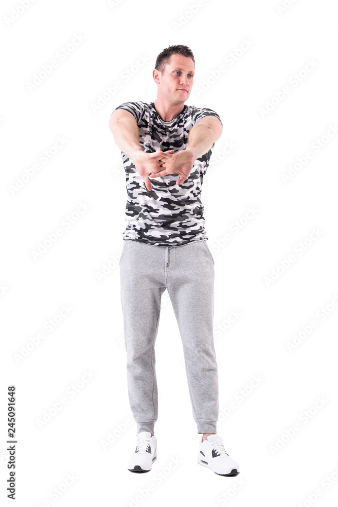 Athletic fit sport man stretching arms warming up and preparing for workout. Full body isolated on white background. Athletic fit sport man stretching arms warming up and preparing for workout. Full body isolated on white background.