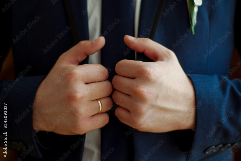 A man holds a jacket collar. Close-up. Wedding day