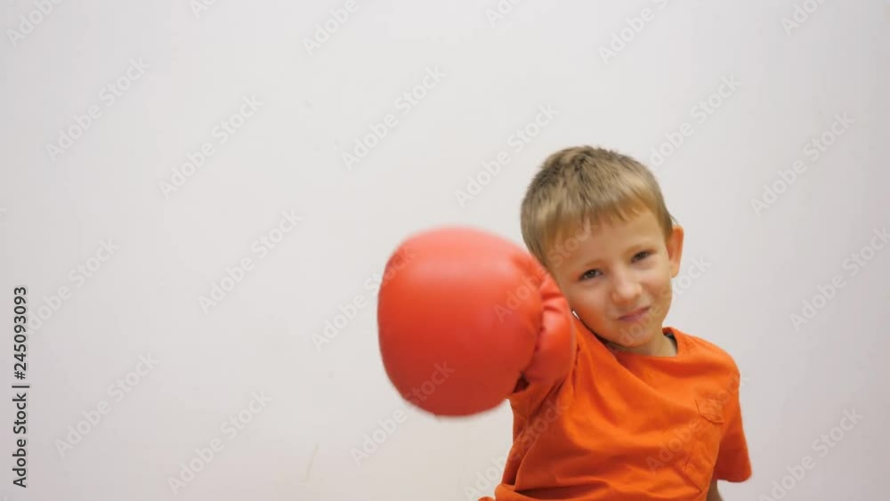 Portrait of child threatening with box gloves, boy throw off his gloves Portrait of child threatening with box gloves, boy throw off his gloves