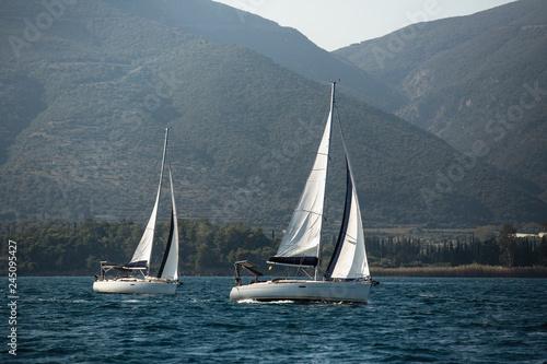 Yachts at sailing regatta in the wind through the waves at Sea.